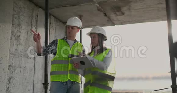 工程师们站在正在施工的建筑物的屋顶上讨论计划和进度视频的预览图