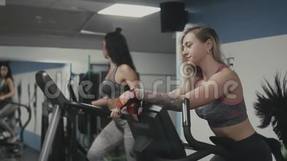 美丽的健身妇女在斯洛莫健身房锻炼椭球和自行车视频的预览图