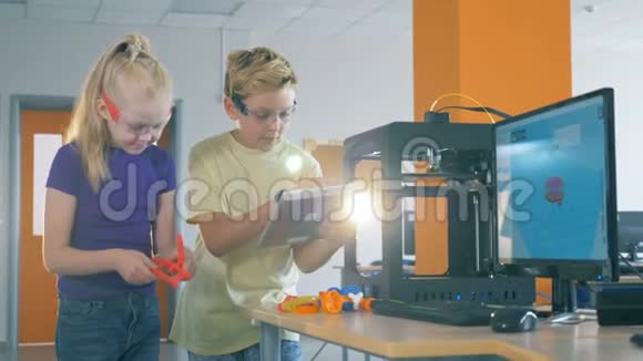 一个男孩和一个女孩在实验室工作发明了3D打印机器人视频的预览图