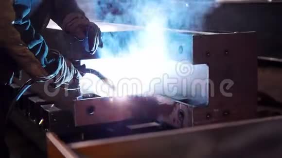 工业概念坐在工作场所使用焊接机的人明亮的蓝色灯光视频的预览图