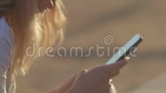 夏天带手机的女孩在海滩上海边旅行近点视频的预览图