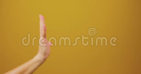 男性和女性的手被连接在一个黄色背景的工作室孤立夫妻爱情家庭手广告视频的预览图