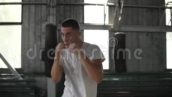 积极愤怒的男性拳击手在健身房的训练过程一个男子拳击与无形对手的肖像拳击旧风格视频的预览图