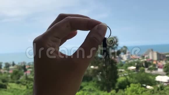 美丽海景背景下女性手握酒店钥匙旅游理念视频的预览图