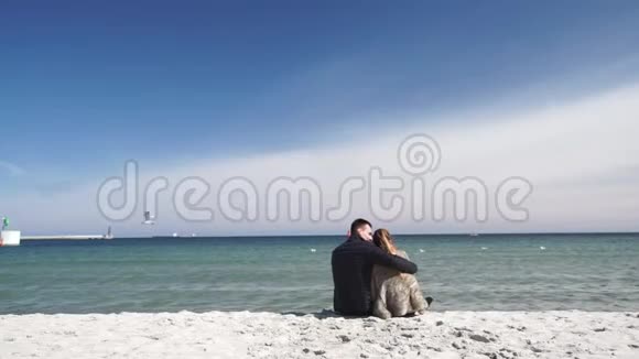 一对恋爱中的情侣在寒冷的一天在沙滩上玩耍视频的预览图