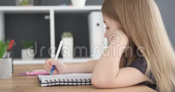 可爱的女孩用钢笔在书上写字视频的预览图
