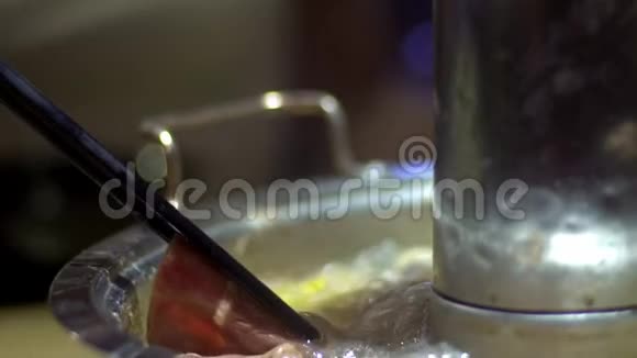 牛肉生肉用筷子缓慢移动北京的中国火锅视频的预览图