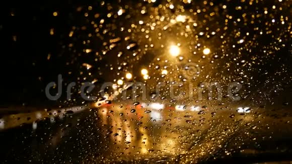 4K雨在前车窗上下着夜路上有路灯和红绿灯视频的预览图