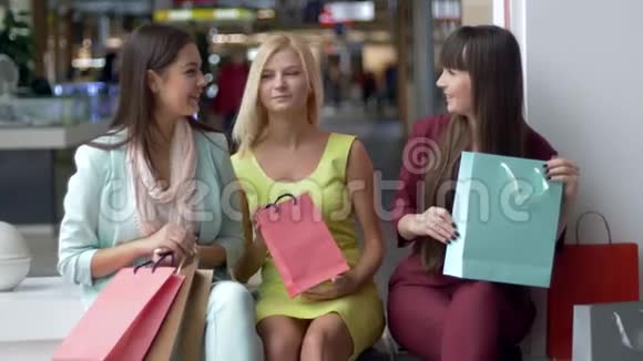 购物狂有吸引力的女人带着许多包裹在商场里讨论她们的购物日视频的预览图