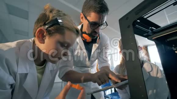 教师和学生使用平板电脑使用3D打印机视频的预览图