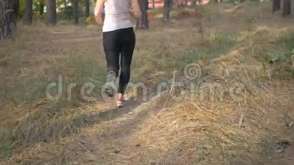 在森林里奔跑的运动鞋中拍摄的女足特写镜头视频的预览图