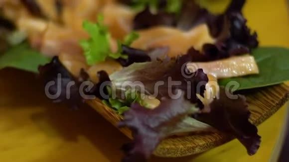 慢动作的美味三文鱼沙咪咪与绿色蔬菜叶视频的预览图