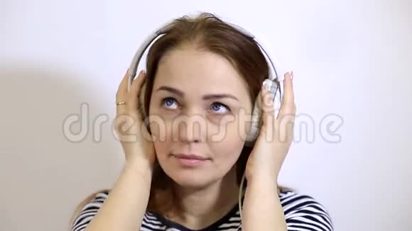 戴着耳机听音乐的白种人留着红色长发的中年妇女视频的预览图