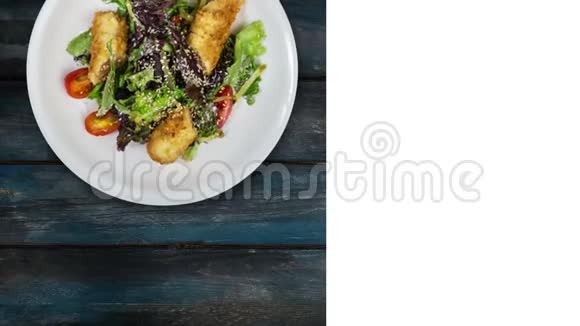 沙拉与三文鱼在面包屑与生菜和芝麻在木制背景上旋转社会广场布局视频的预览图