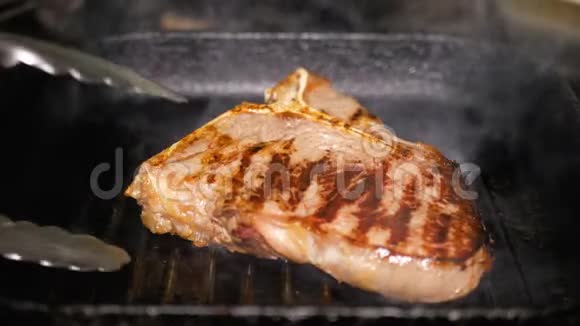 鲜熟的提邦牛排是从一个热烤盘使用钢钳美味的烤小牛肉炸肉视频的预览图