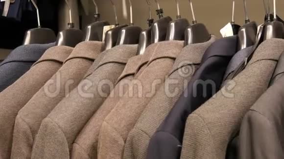 在商场的一家男士服装店一排暖男夹克衫在衣架上各种男士西装挂在购物中心视频的预览图