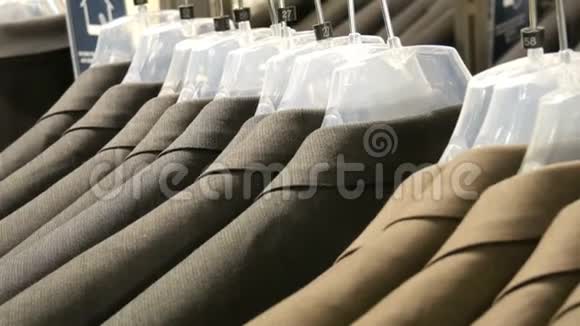 棕色和灰色的男士夹克挂在商场的男士服装店的衣架上一大群男人穿西装视频的预览图