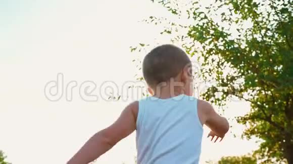 穿着白色t恤的4岁男孩笑着伸出双手活泼开朗的孩子对大自然的描绘视频的预览图