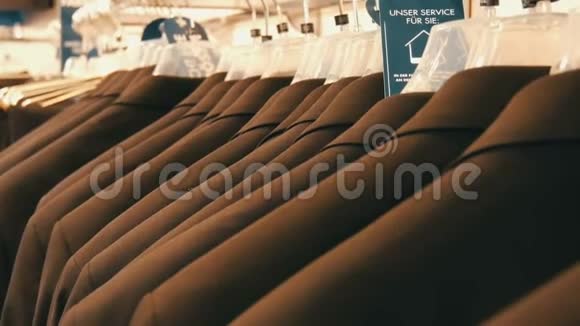 在商场的服装店里同色西装挂在衣架上的男人的数量视频的预览图