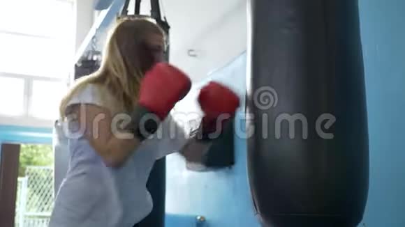 运动和人女拳击手戴手套在健身房里打重袋视频的预览图