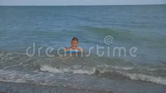 男孩正在沿海波浪中围成一个圆圈游泳视频的预览图