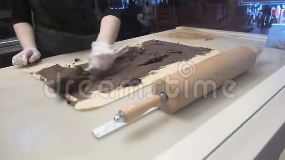场景厨师在面团片上涂上肉桂生产肉桂卷面包制品视频的预览图
