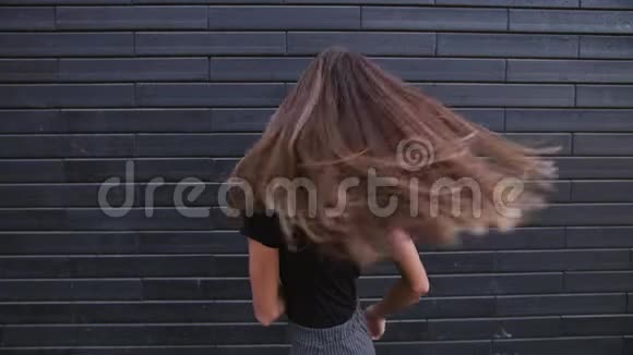 一位美丽的年轻女子棕色头发在风和日丽的慢动作中微笑视频的预览图