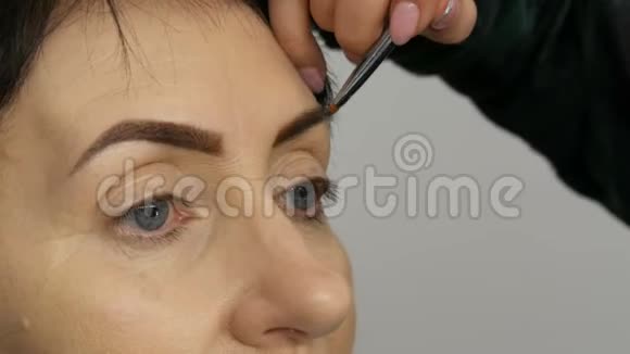 一种特殊的画笔用眉毛阴影描绘眉毛近景专业化妆师化妆到中间视频的预览图
