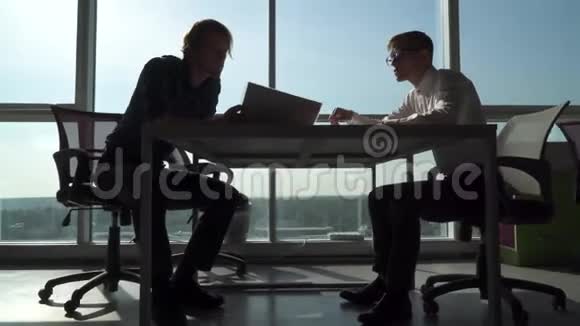 两个人在办公室的桌子旁握手视频的预览图