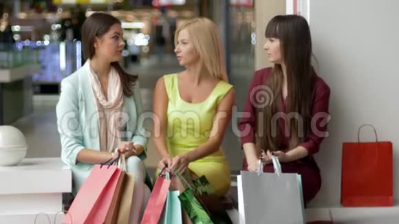 黑色星期五女士们玩得很开心坐在商场里一起讨论她们的购买事宜然后相机和视频的预览图