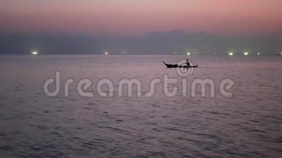 日落时分在海上渔船灯光之间的人浅顶剪影航运图片视频的预览图
