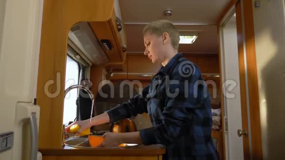 一个女人在汽车屋里洗碗汽车旅行概念视频的预览图