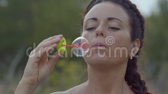 慢动作美丽的女人带着硬币跑肥皂泡在晚上视频的预览图