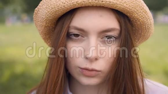 一位红头发的年轻女子闭着眼睛站着睁开眼睛视频的预览图