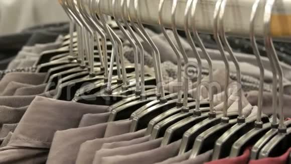 在购物中心的男装商店里一排排各种时尚男士衬衫在一个巨大的衣架上视频的预览图