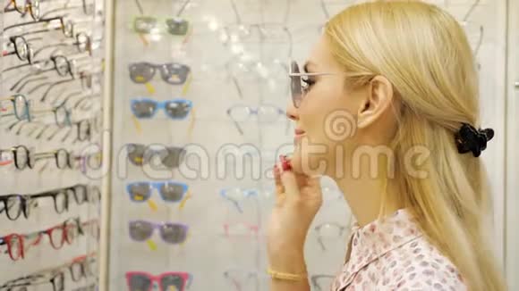年轻女子正在眼镜店里挑选太阳眼镜视频的预览图