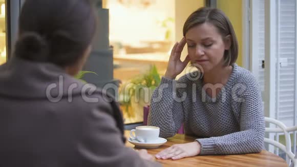 在咖啡馆里安慰难过的女朋友的女士有着信任关系的姐妹视频的预览图