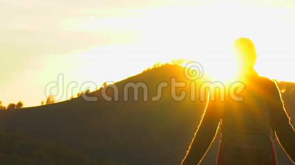 徒步旅行者女的剪影手臂举在山顶看日落徒步旅行者女孩旅行者女视频的预览图