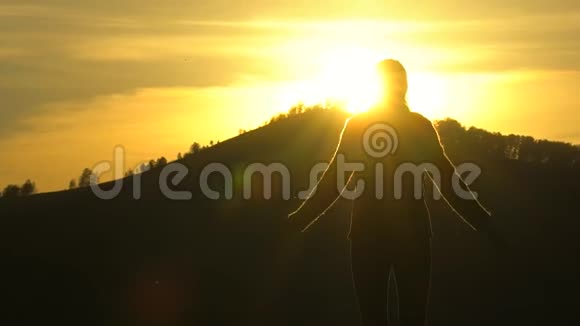 徒步旅行者女的剪影手臂举在山顶看日落徒步旅行者女孩旅行者女视频的预览图