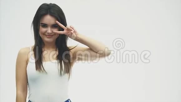 白色背景下年轻漂亮女孩的手势不同的手势和舌头表现出情感视频的预览图
