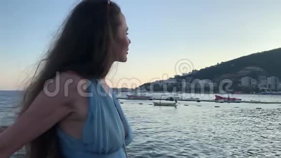 穿着蓝色裙子的美女站在海边参加活动视频的预览图
