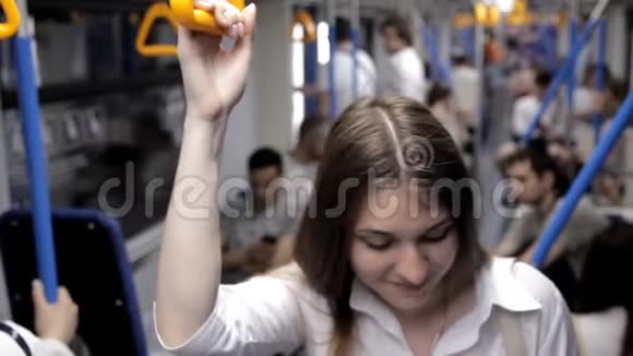 一个漂亮的女孩去地铁握住扶手用电话视频的预览图