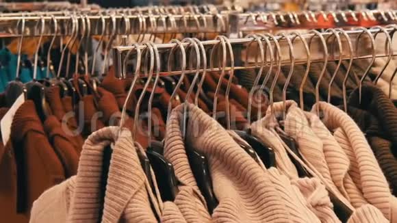 一大批妇女温暖的衣服挂在衣架上躺在购物中心的服装店的货架上视频的预览图