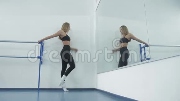 漂亮的运动女孩站在宽敞的窗户上表演现代舞的动作视频的预览图