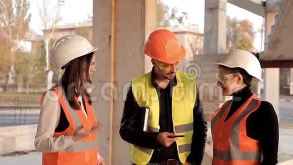 建筑工人和女建筑师讨论施工计划并为相机摆好姿势建造新的视频的预览图
