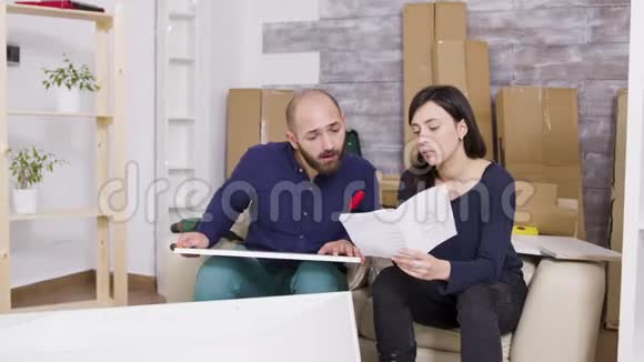 一对夫妇用新公寓的说明书组装家具视频的预览图