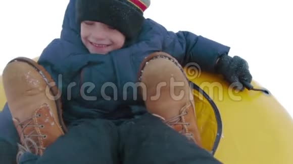 观点快乐的小男孩在山上滑过雪地在跳板上慢动作视频的预览图