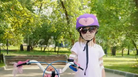 戴着紫色自行车头盔的小女孩的肖像视频的预览图