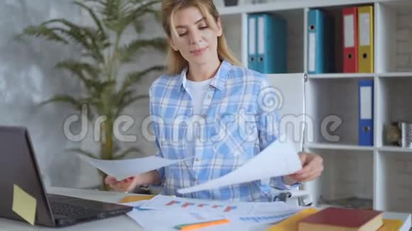 专注于商业的女人在自己的办公室里用纸工作4K视频的预览图