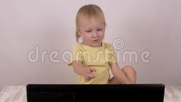 金发女郎微笑着按下笔记本电脑上的按钮看着电脑放松一下视频的预览图